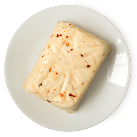 Block of halloumi cheese with red chilli on white ceramic plate isolated on white. Top view.の写真素材