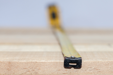 tape measure on the brown wooden backgroundの写真素材