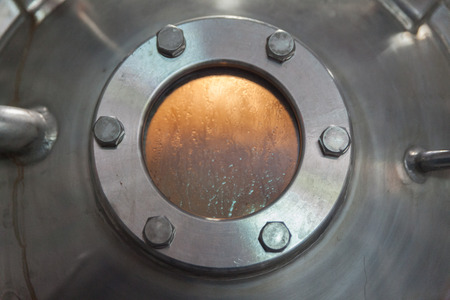 close up porthole window in factory tankの写真素材