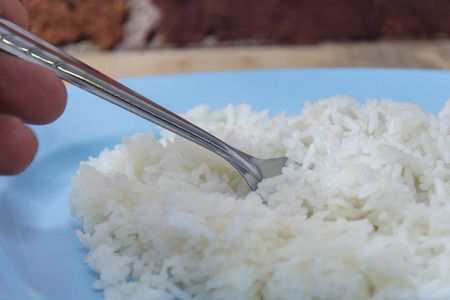 cooked rice in plate, boiled ice with spoon and forkの写真素材