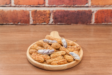 close up of boiled peanuts on wooden plate