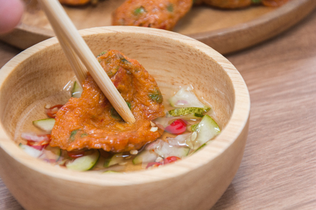 Fried Fish-paste balls on wooden plate with chopsticksの写真素材