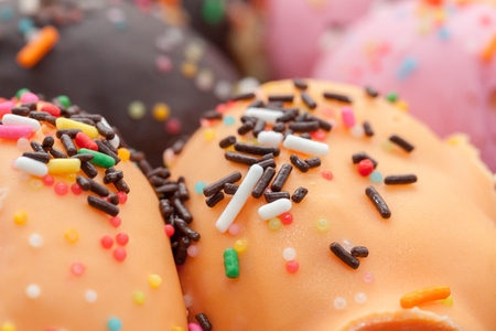 a variety of doughnut on wooden plate with sprinklesの写真素材