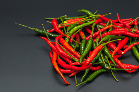 red and green chilli hot pepper on black backgroundの写真素材