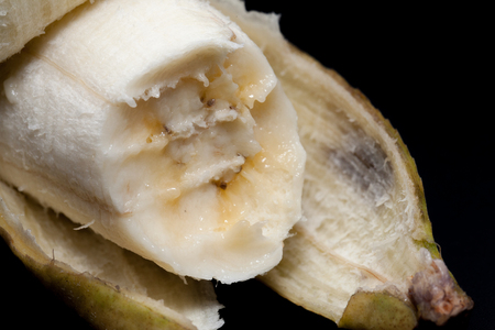 a bitten of banana on black backgroundの写真素材
