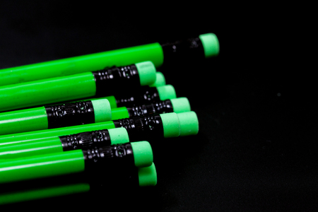 a row of green pencil on black backgroundの写真素材