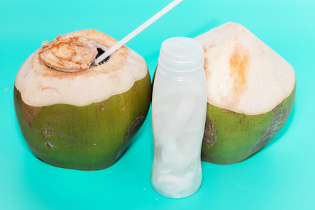 coconut with drinking straw, notebook and sunglasses on blue backgroundの写真素材