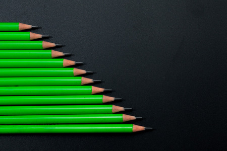 a row of green pencil on black backgroundの写真素材