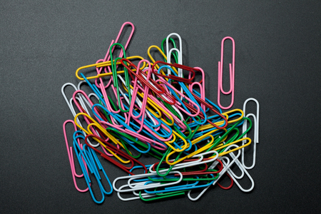 pile of different color paper clip on black backgroundの写真素材