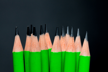 a row of green pencil on black backgroundの写真素材