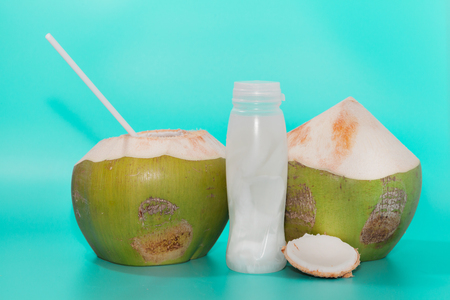 coconut with drinking straw, notebook and sunglasses on blue backgroundの写真素材