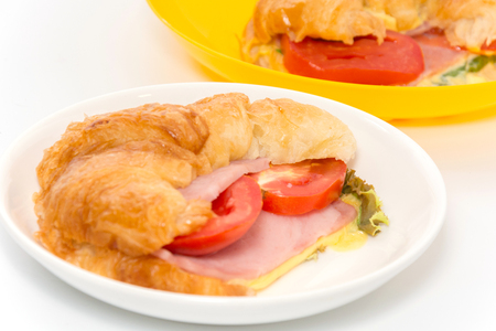 croissant ham and cheese on white plateの写真素材