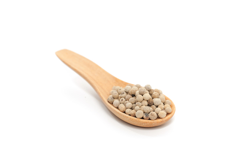 Pile of pepper on wooden spoon isolated on white background の写真素材
