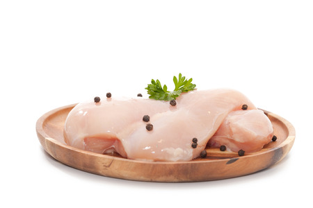 Raw chicken breast,peppers and parsley on wooden plateの写真素材