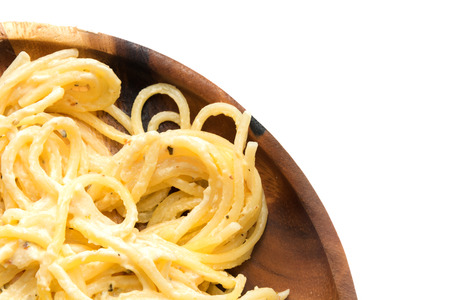 Spaghetti carbonara with cream on wooden plate on white backgroundの写真素材