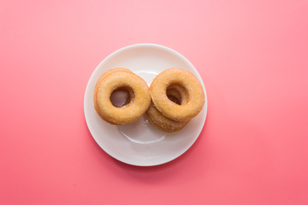 Fried Donuts with sugar topping on pink backgroundの写真素材