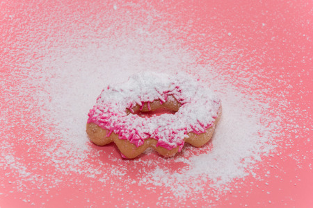 Fried Donuts on pink background with Powdered sugar icingの写真素材