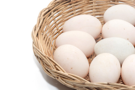 raw dirty duck eggs in basket on white backgroundの写真素材