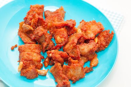 fired pork with garlic on blue plateの写真素材