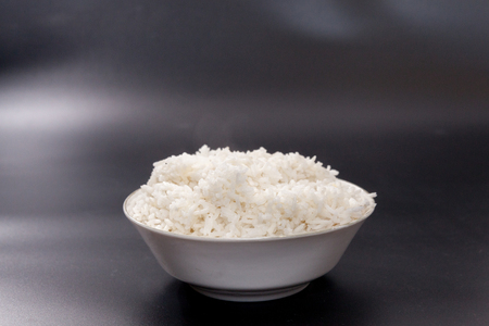 cooked rice on bowl on black backgroundの写真素材