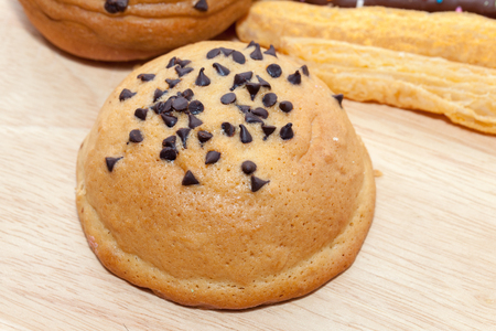 Chocolate Chips Coffee Bun on wooden plateの写真素材