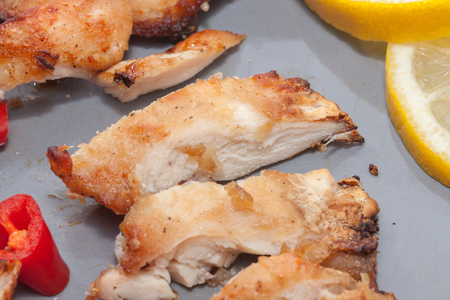 Roast chicken with chilli, lemon on grey plateの写真素材
