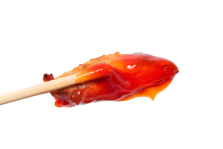 close up of chopstick and chicken breast with sauceの写真素材
