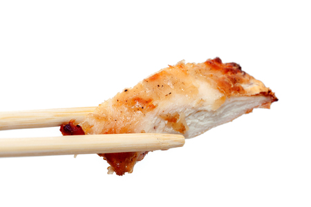 close up of chopstick and chicken breast with sauceの写真素材