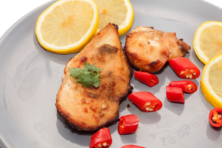 Roast chicken with chilli, lemon on grey plateの写真素材