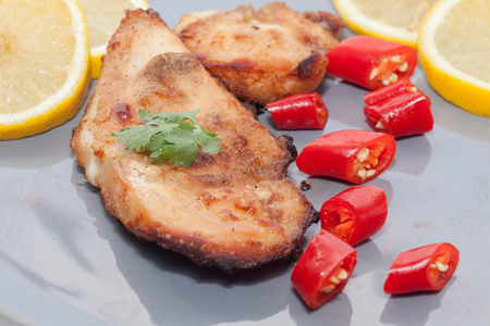 Roast chicken with chilli, lemon on grey plateの写真素材