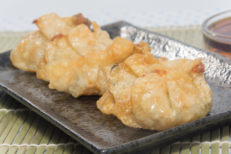 fried pork gyoza dumplings on black plateの写真素材