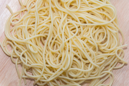 spaghetti without sauce with fork on wooden plateの写真素材