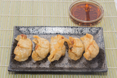 fried pork gyoza dumplings on black plateの写真素材