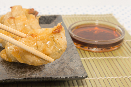 fried pork gyoza dumplings on black plateの写真素材