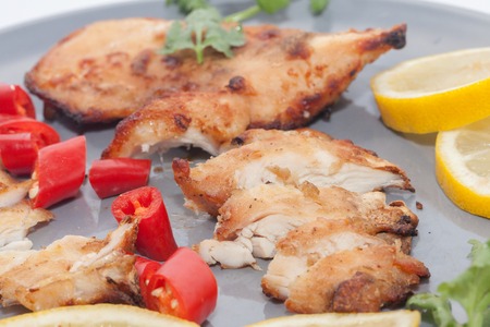 Roast chicken with chilli, lemon on grey plateの写真素材