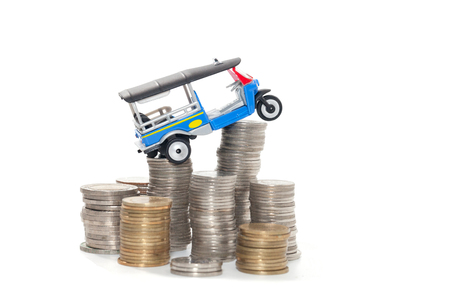 Thai traditional tuk tuk toy and coin on white backgroundの写真素材