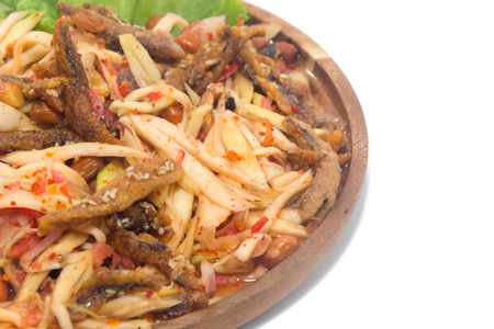 spicy green mango salad on wooden plateの写真素材