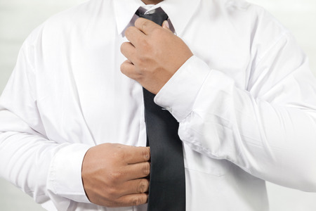 businessman in white shirt taking off neck tieの写真素材