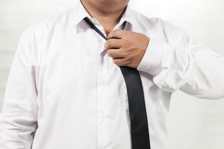 businessman in white shirt taking off neck tieの写真素材