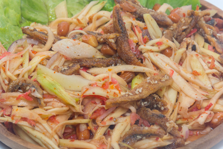 spicy green mango salad on wooden plateの写真素材