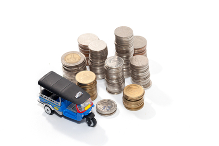 Thai traditional tuk tuk toy and coin on white backgroundの写真素材