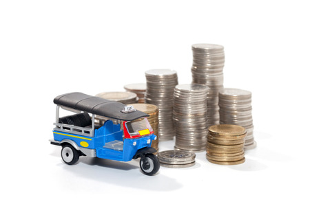 Thai traditional tuk tuk toy and coin on white backgroundの写真素材