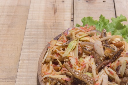 spicy green mango salad on wooden plateの写真素材