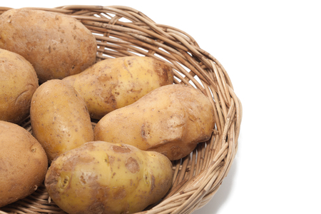 potato on basket isolated on white backgroundの写真素材
