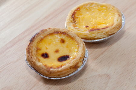 close up of egg tarts on wooden plateの写真素材