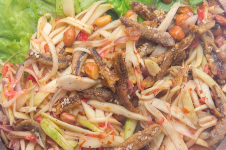spicy green mango salad on wooden plateの写真素材