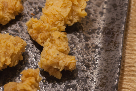 close up of fried chickens on black plateの写真素材