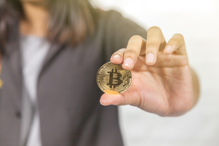 close up of hand holding bitcoin on white backgroundの写真素材