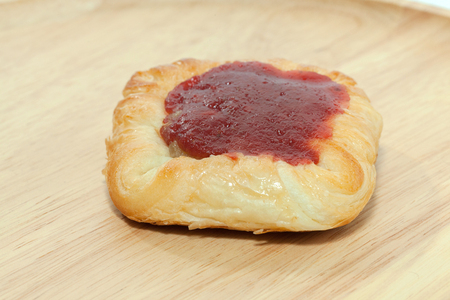 close up of strawberry danish on wooden plateの写真素材