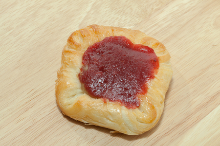 close up of strawberry danish on wooden plateの写真素材